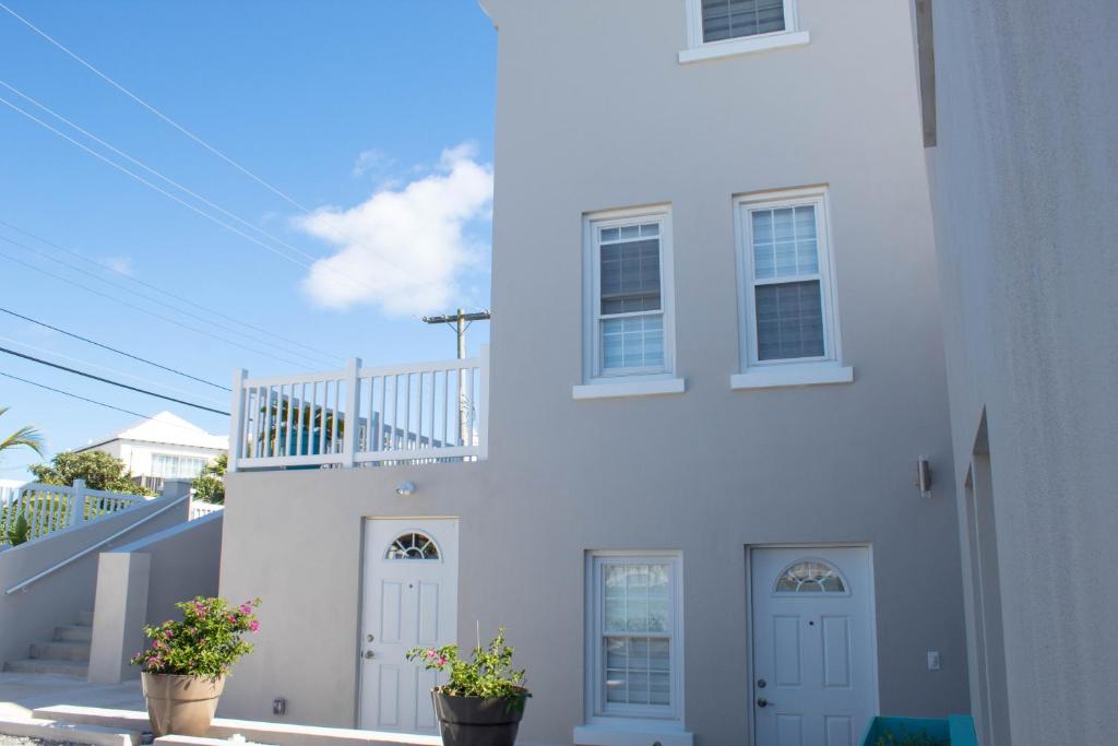 PembrokeCavendish Heights Suites的两扇门和两盆植物的白色房子