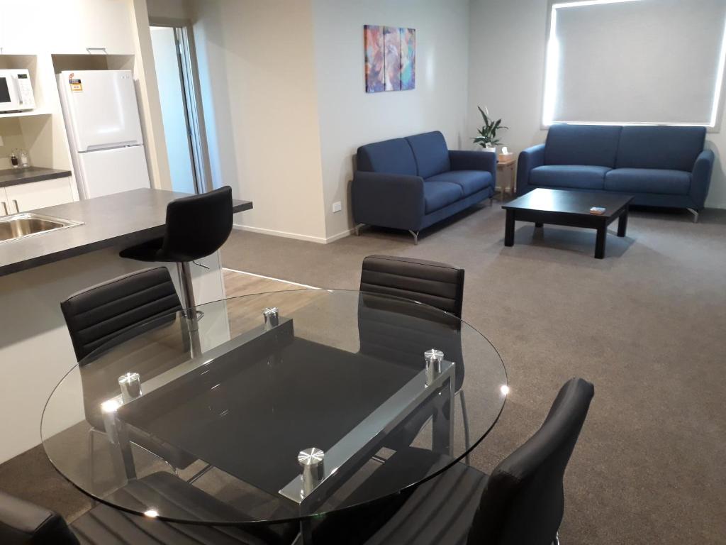 因弗卡吉尔South City Accommodation Unit 1的客厅配有玻璃桌和椅子