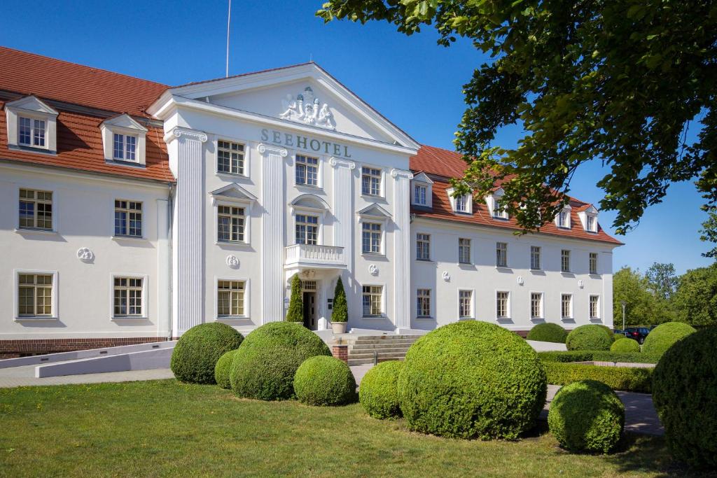 大雷申格罗斯雷申希酒店的前面有灌木丛的白色大建筑