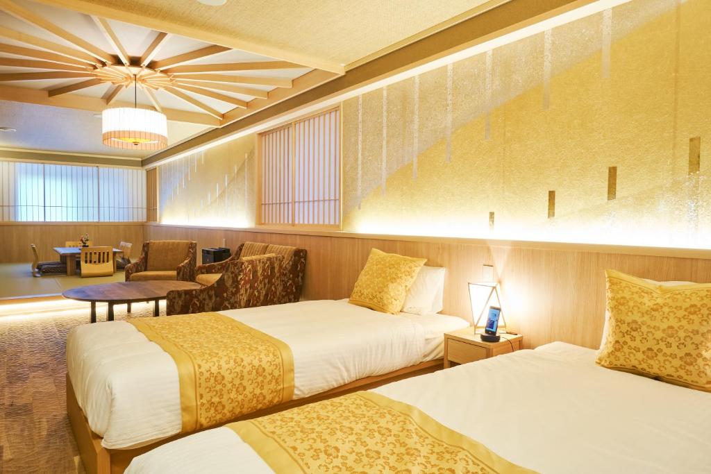 金泽SHIKI Seasonal Colors Kanazawa的酒店客房,配有两张床和椅子