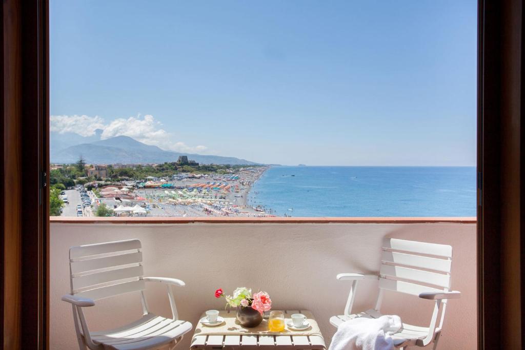 斯卡莱阿玫瑰大酒店的阳台享有海滩美景,配有两把椅子