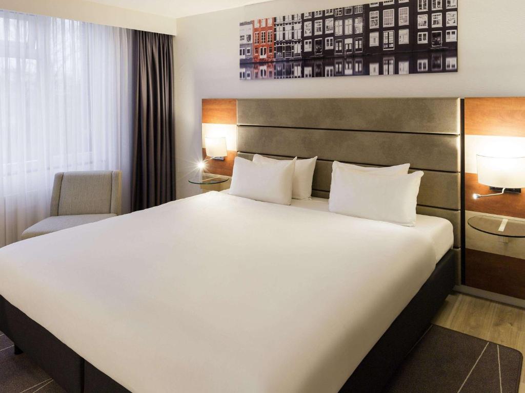 阿姆斯特丹阿姆斯特丹西美居酒店的一张大白色的床,位于酒店客房内
