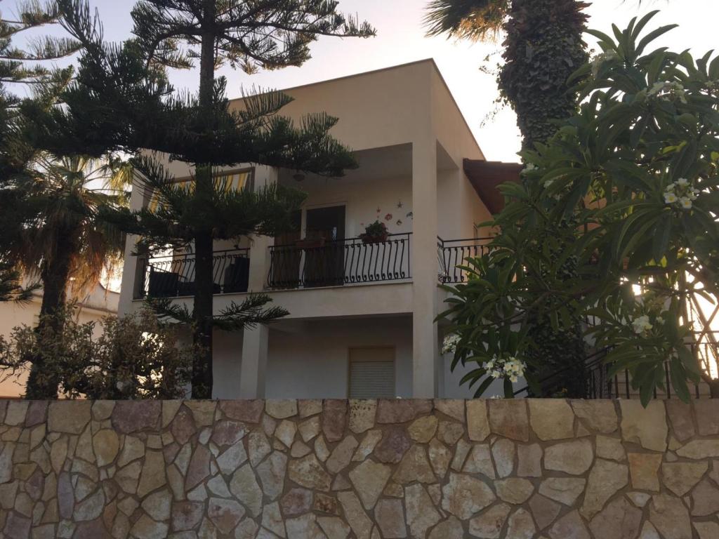 夏卡Villa Vella的白色的房屋,有树木和石墙