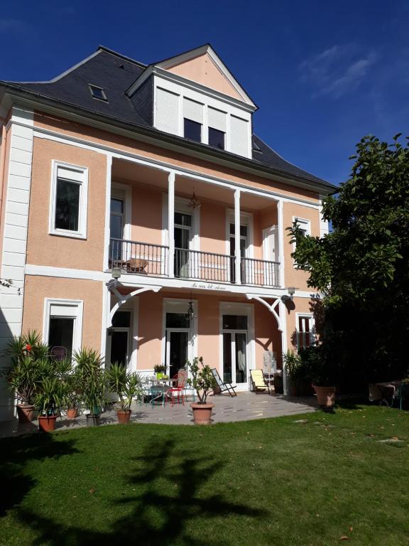 巴涅尔德比戈尔罗利路住宿加早餐旅馆的一座大型粉红色房屋,设有阳台和庭院。