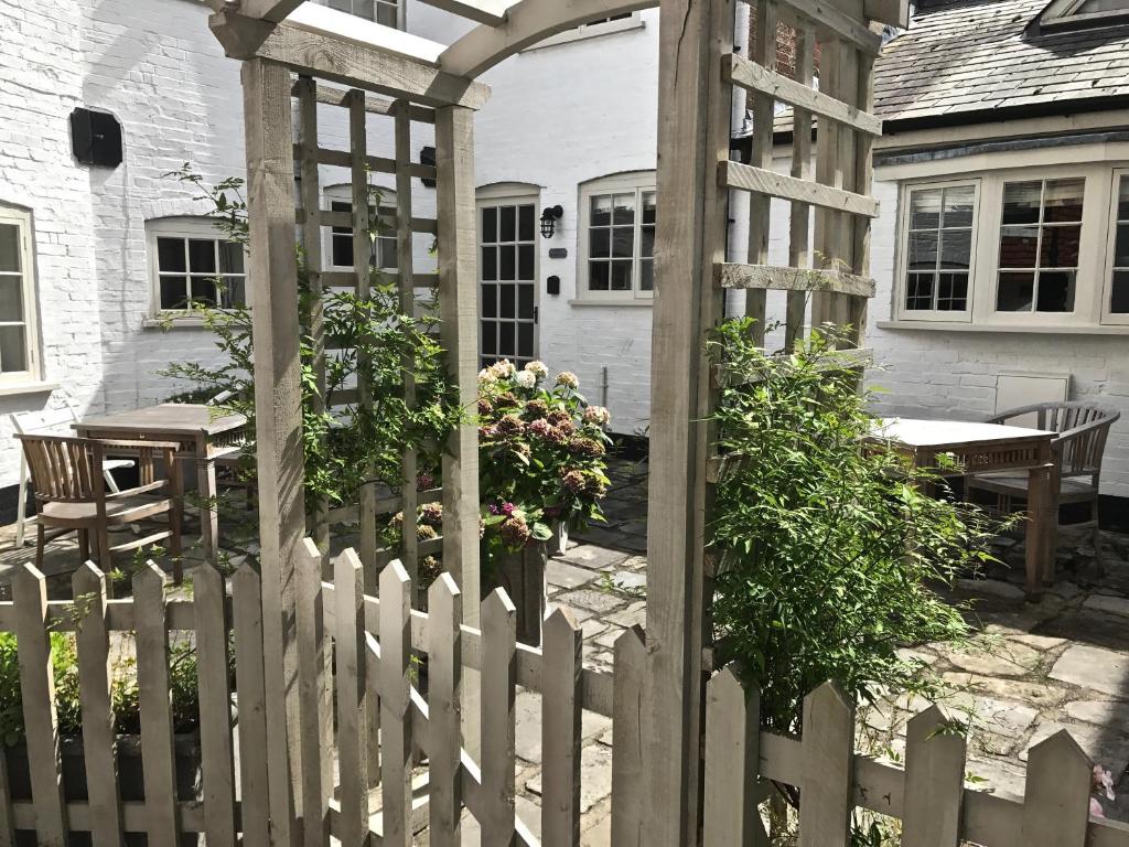 利明顿Courtyard Cottages Lymington, 2 Adults only的房屋前有木门的白色围栏