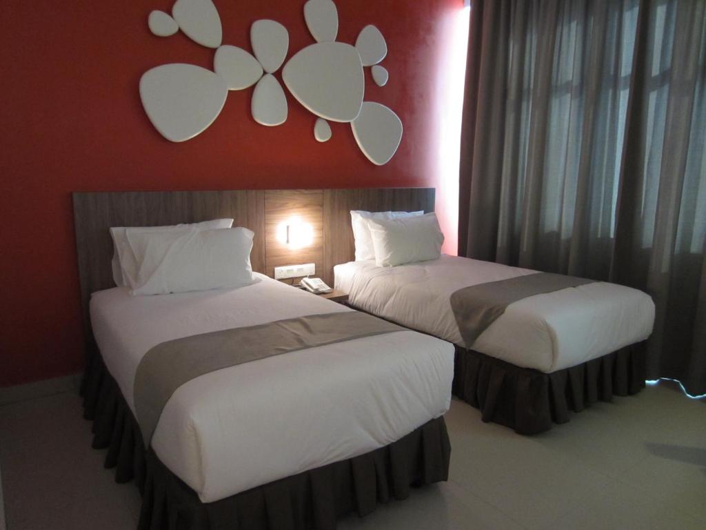 斯里伊斯兰德D酒店的两张睡床彼此相邻,位于一个房间里