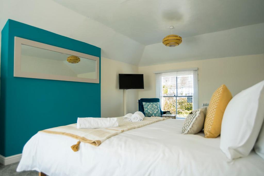 彭赞斯Victoria Inn的一间卧室设有一张蓝色墙壁的大床