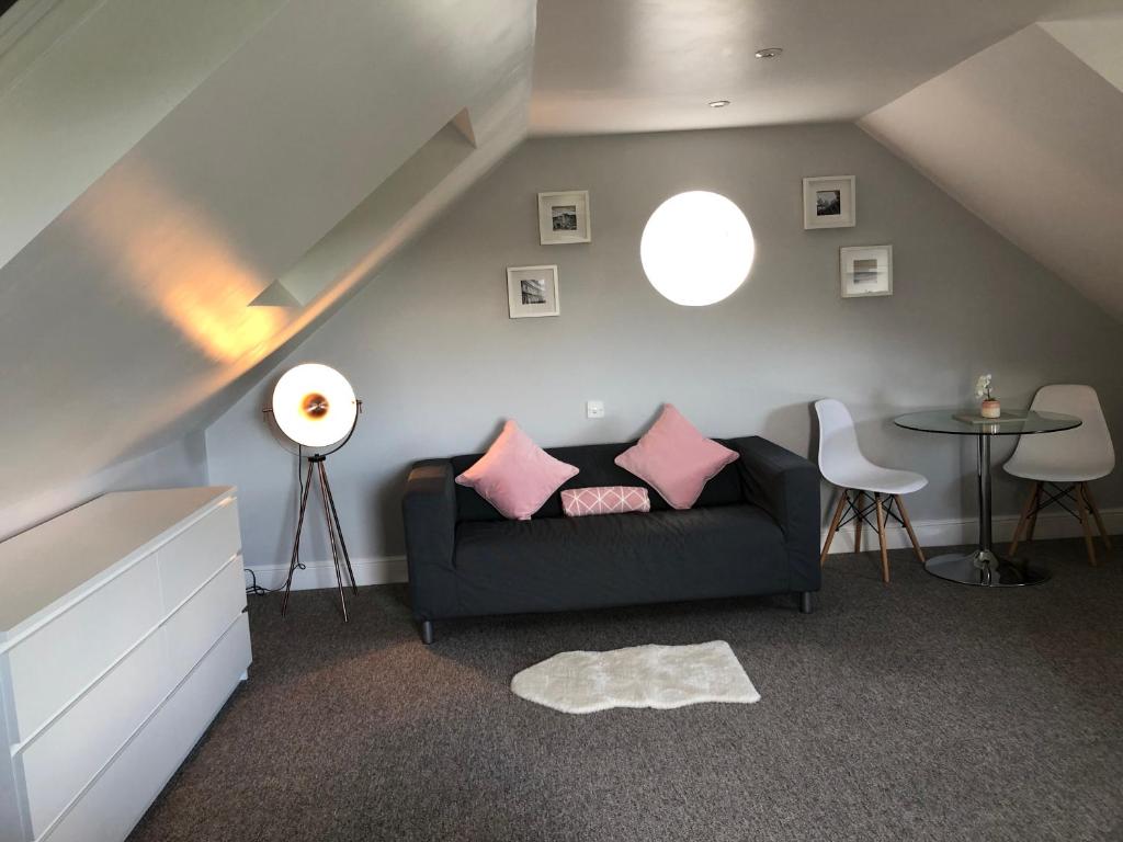 巴斯The Annexe的客厅配有黑色沙发和粉红色枕头。