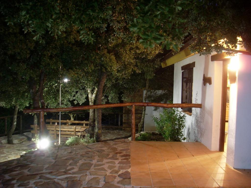 托雷斯Casas Rurales Cortijos el Encinar的夜间有栅栏的房子的门廊