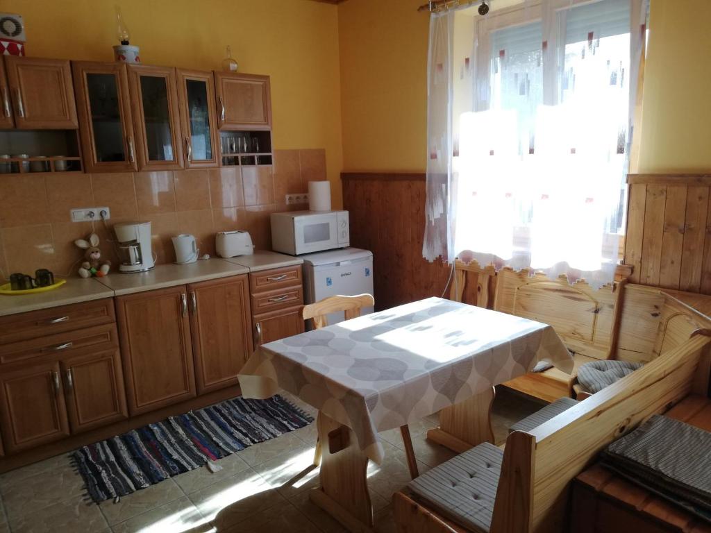 鲍洛通塞迈什Apartment in Balatonszemes 38456的厨房配有桌子、桌子和微波炉