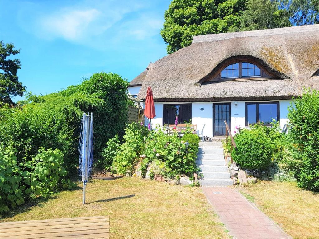 格罗斯齐克Ferienhaus mit Reetdach und Seebli的小屋设有茅草屋顶和庭院。