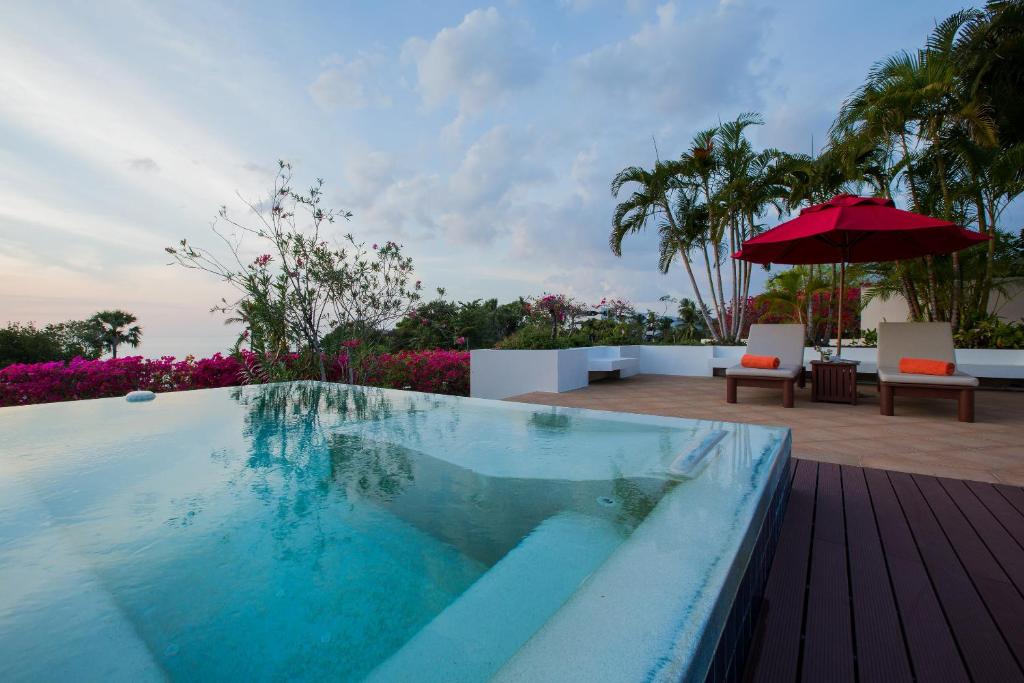 卡塔海滩Ocean views Kata gardens penthouse 6C的甲板上带遮阳伞的游泳池