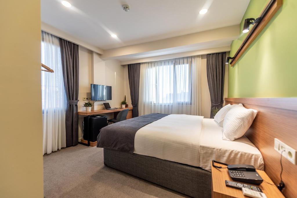 伊斯坦布尔Bram Hotel Istanbul的配有一张床和一张书桌的酒店客房