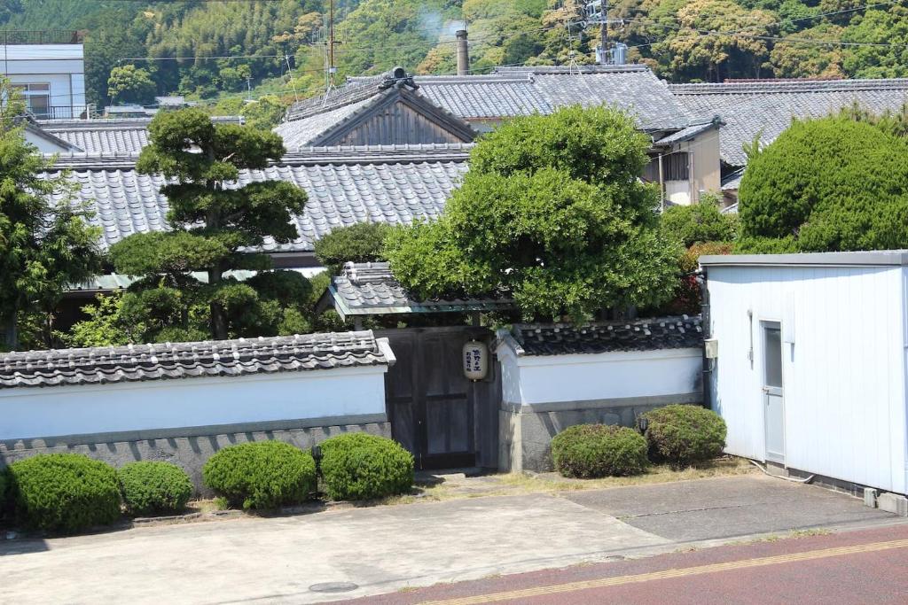 熊野市沃家池凯旅馆的带有门和灌木的房子的图象
