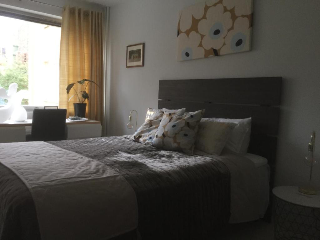 赫尔辛基Lovely Apartment, Vuorimiehenkatu 31的卧室配有带枕头的床铺和窗户。