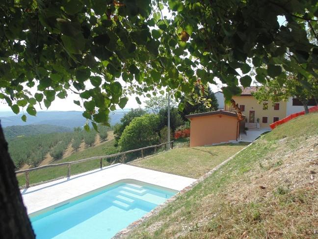 维罗纳Agriturismo Corte Maccini的房子边的蓝色游泳池