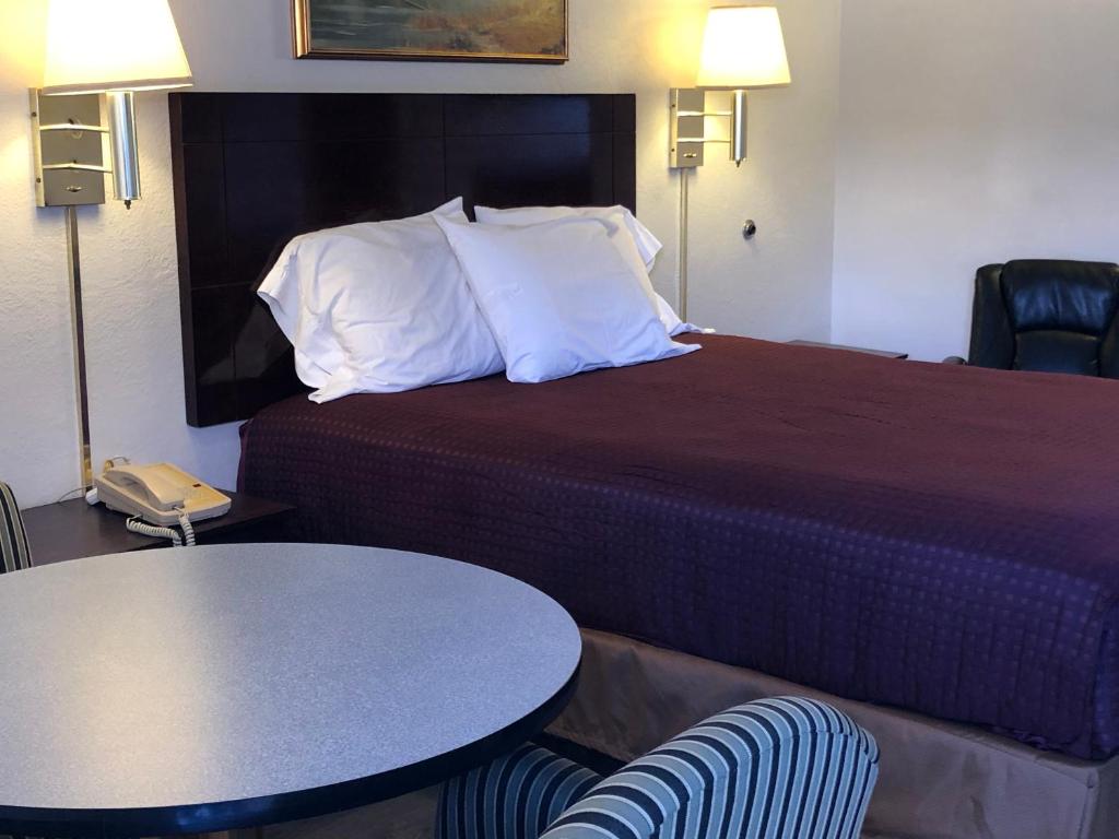 阿拉莫戈多阿拉莫戈多经济旅馆的酒店客房带一张床、一张桌子和椅子