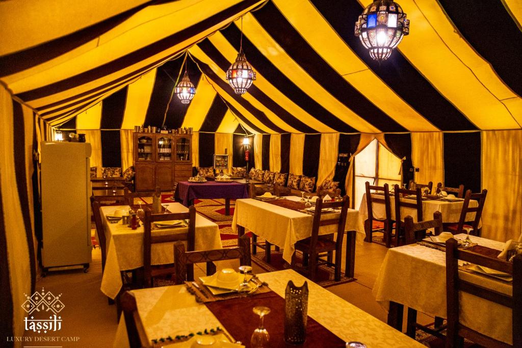 梅尔祖卡Tassili Luxury Desert Camp的帐篷内带桌椅的用餐室