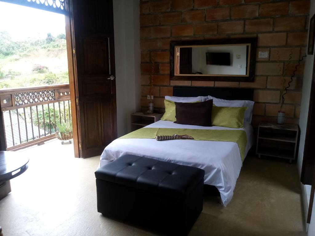 El Carmen de AtratoHotel Casa Lily的一间带大床的卧室和一个阳台