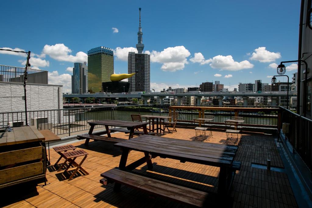 东京东京第二章旅舍的一个带野餐桌和椅子的甲板,享有城市天际线