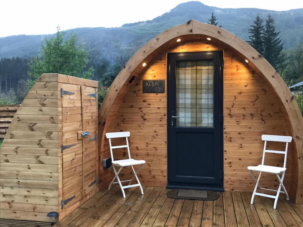 斯特拉西尔Strathyre Camping Pods的小屋设有两把椅子和一扇门