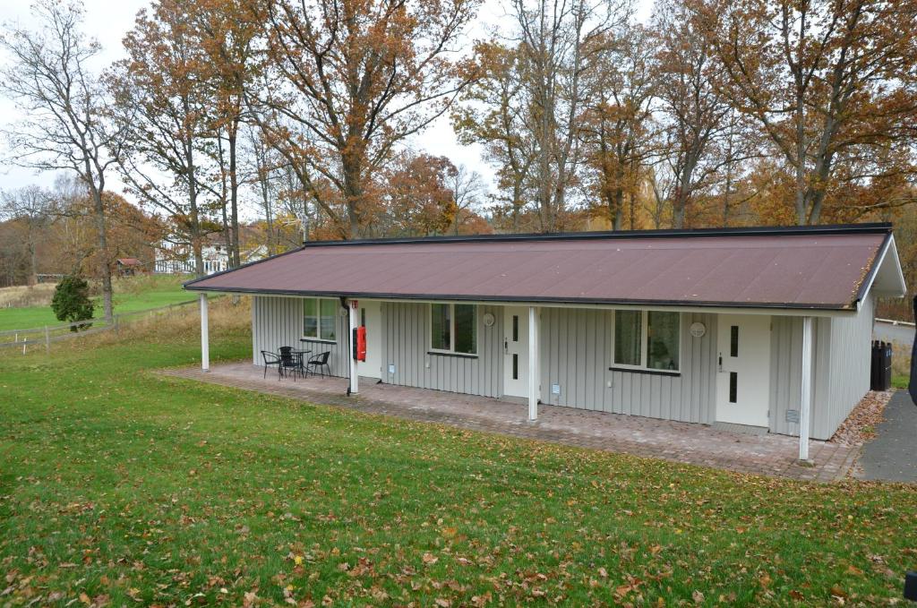 阿灵索斯Alingsås Golfklubb的一间白色的小房子,有金属屋顶