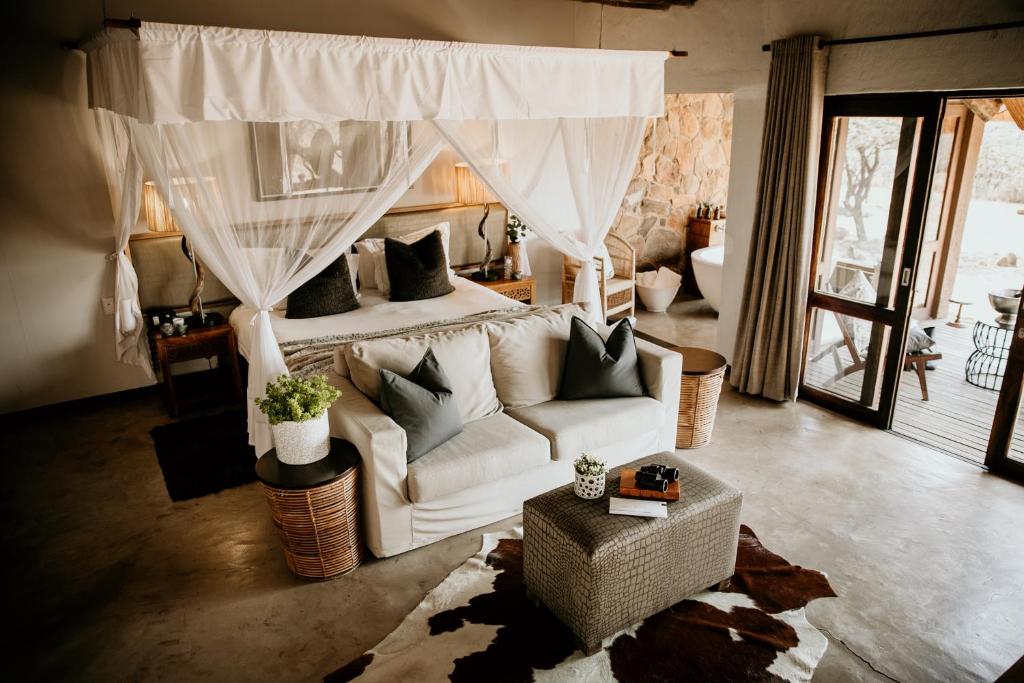 纳姆比提动物保护区Nambiti Hills Private Game Experience的客厅配有白色的沙发和床。