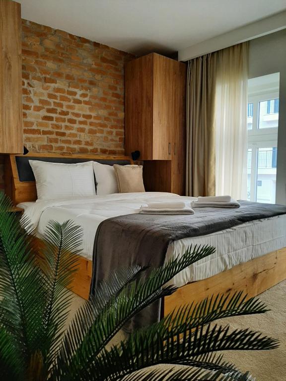 贝尔格莱德Urban Lodge Belgrade的一间卧室设有一张带砖墙的大床