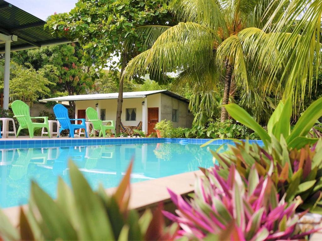 莫约加尔帕Hospedaje Soma Ometepe Hotel的一个带椅子和棕榈树的游泳池的度假酒店