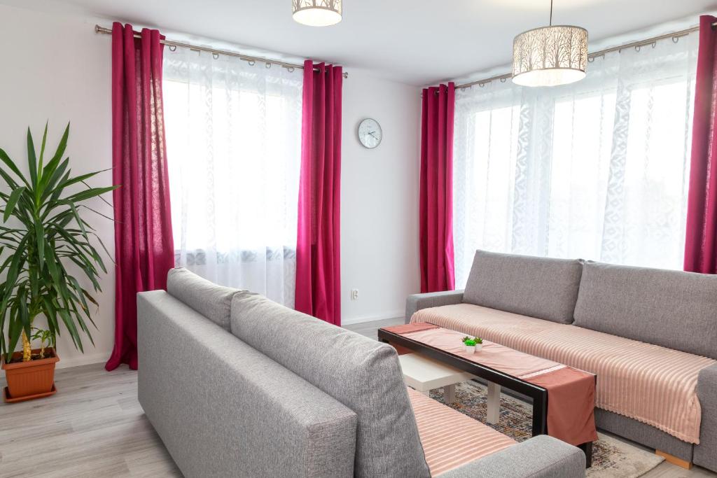 什切青Apartament Yooka的客厅配有两张沙发和红色窗帘