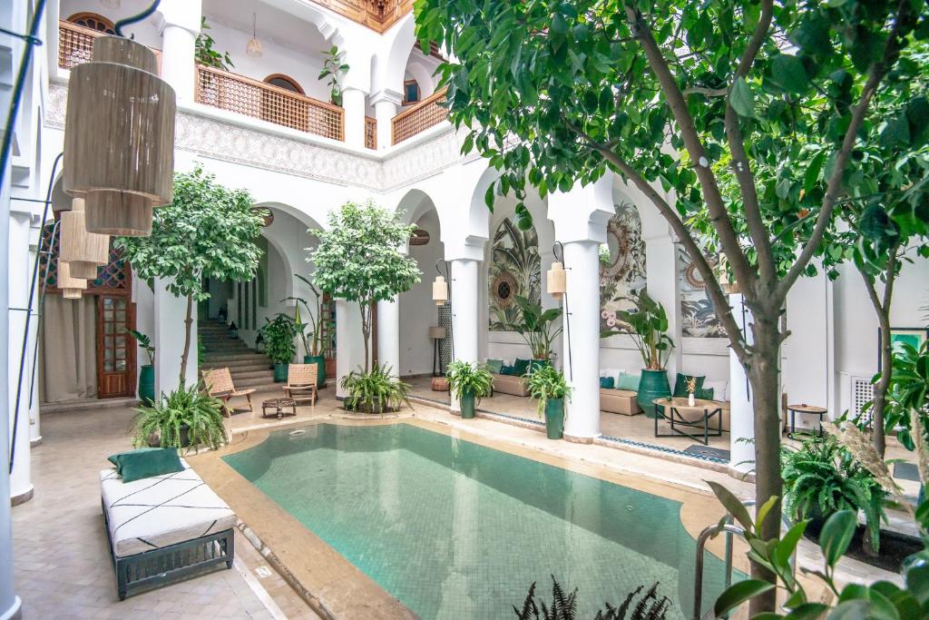 马拉喀什卡利帕宫酒店的一座树木繁茂的建筑的庭院里的一个室内游泳池