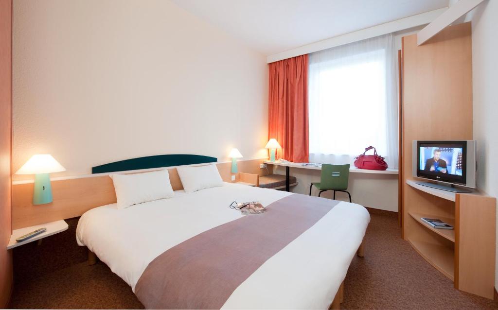 里瓦日卢森堡南部宜必思酒店的酒店客房设有一张大床和一台电视。