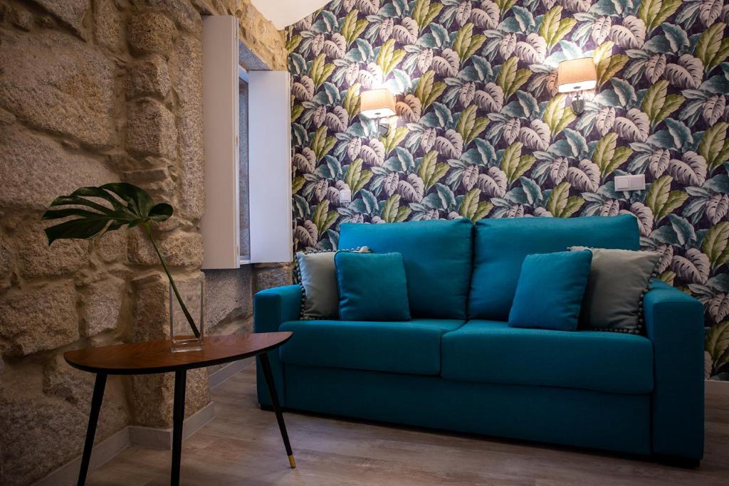 波尔图Casa Jardim By Alojamento Ideal的客厅里一张蓝色的沙发,配有花卉壁纸
