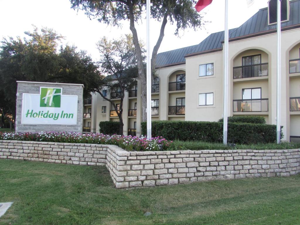 欧文Holiday Inn Irving Las Colinas, an IHG Hotel的前面有标志的建筑