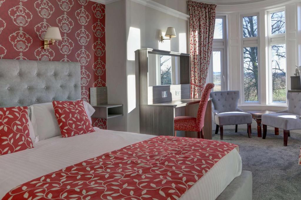 洛克比Sure Hotel by Best Western Lockerbie的一间卧室配有一张床、一张桌子和一把椅子