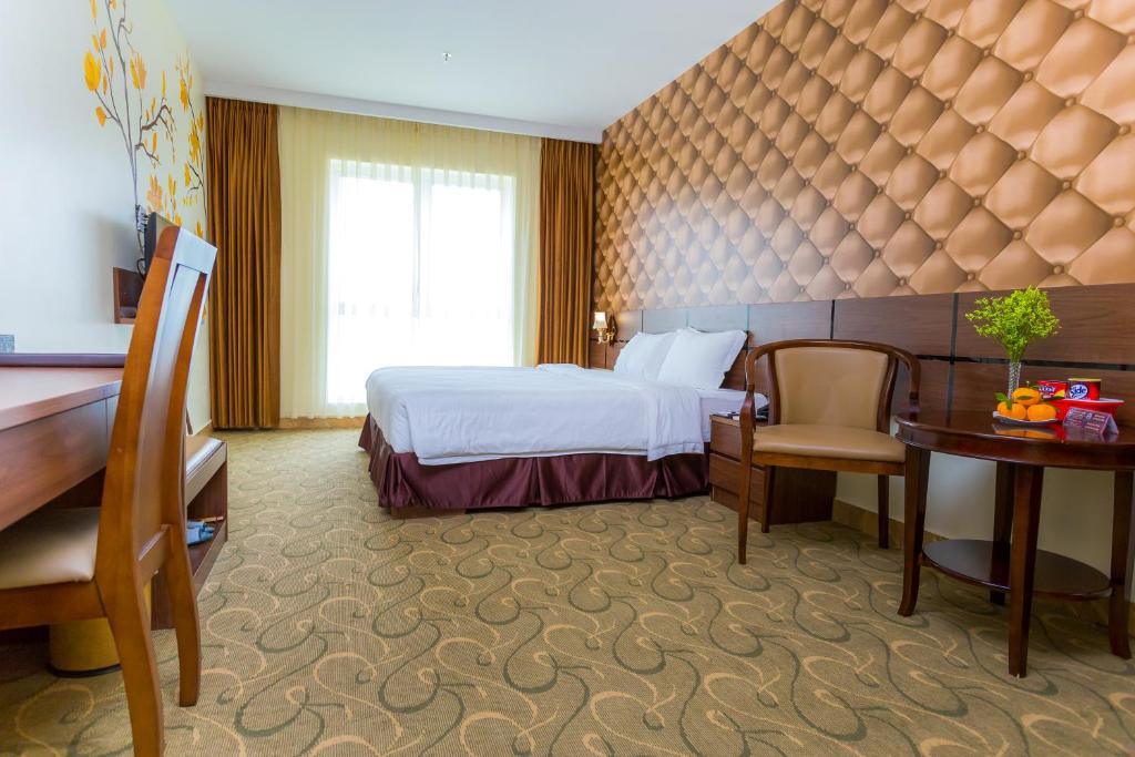 海防3MG Lakeside Hotel的配有一张床和一张书桌的酒店客房