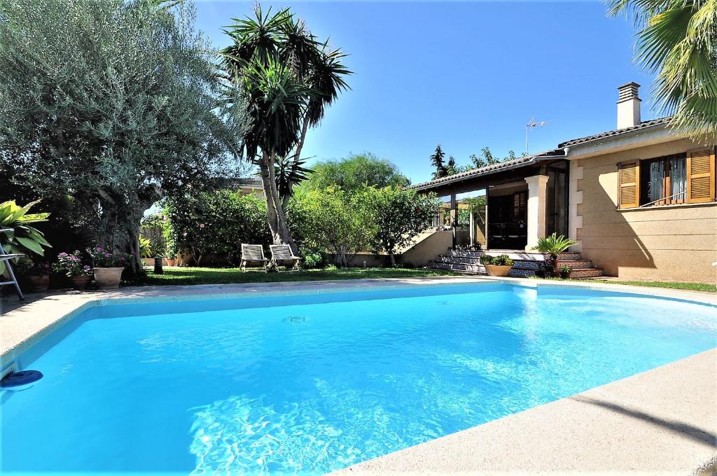 马略卡岛帕尔马"PEP POMAR" Chalet en Palma de Mallorca的一座大蓝色游泳池,位于房子前