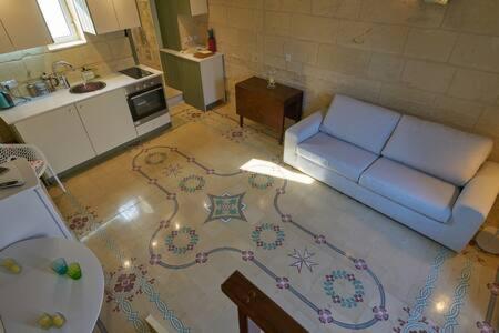维多利亚Magic in the Heart of Old Gozo (Penthouse)的一间带蓝色沙发的客厅和一间厨房