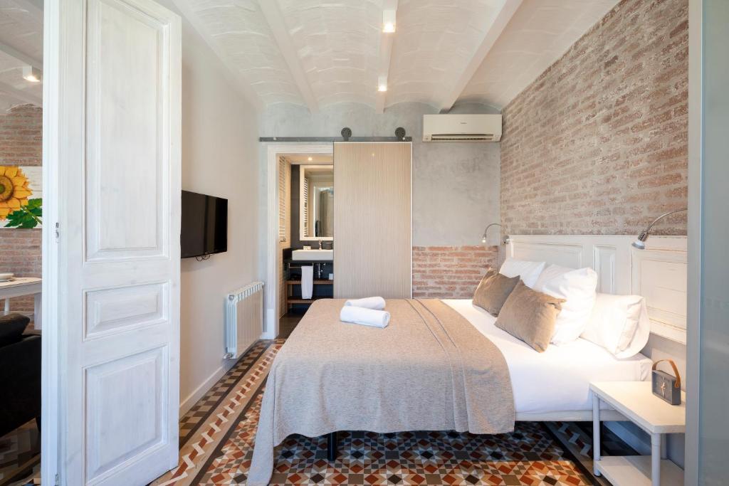 巴塞罗那阿斯帕西奥富思特公寓的一间卧室设有一张床和砖墙