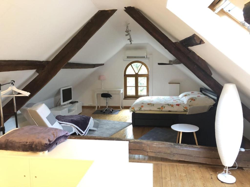 格雷弗拉特Ferienwohnung auf denkmalgeschütztem Sturmhof的阁楼卧室配有1张床和1张书桌