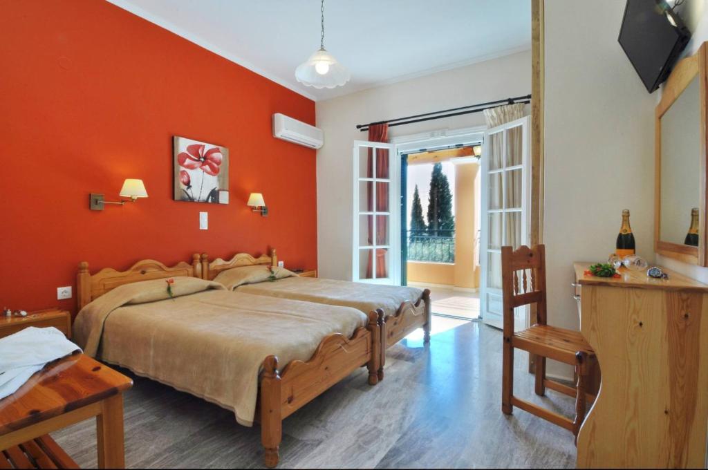 帕莱欧卡斯提撒Rhea Complex的一间卧室配有一张带橙色墙壁的大床