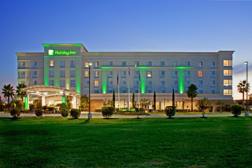 大学城Holiday Inn & Suites College Station-Aggieland, an IHG Hotel的一座绿灯环绕的大型建筑