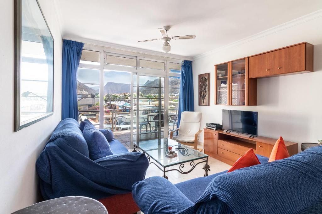 莫甘Flatguest Mogan + Beach + 2Bdr + Terrace的客厅配有蓝色的沙发和电视