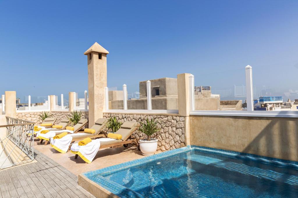 索维拉Suite Azur Hotel的一座带躺椅的建筑屋顶上的游泳池