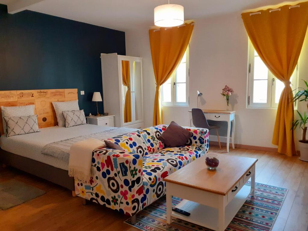 圣艾米隆Hôtes de Saint-Emilion I的一间卧室配有一张床、一张沙发和一张桌子