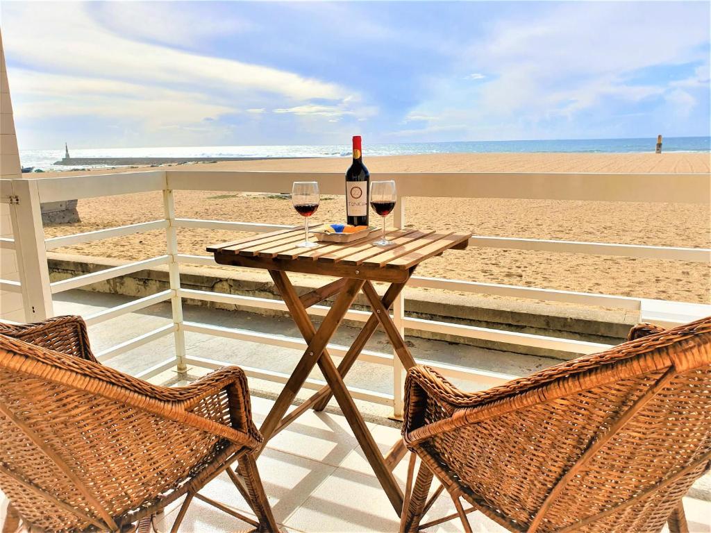 ArcozeloHouse in beach- Oporto的一张桌子,上面有两杯葡萄酒在沙滩上
