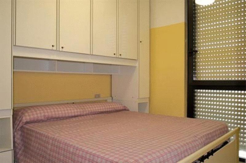 坎波马里诺内图诺公寓式酒店的一间卧室配有一张带粉红色 ⁇ 床罩的床