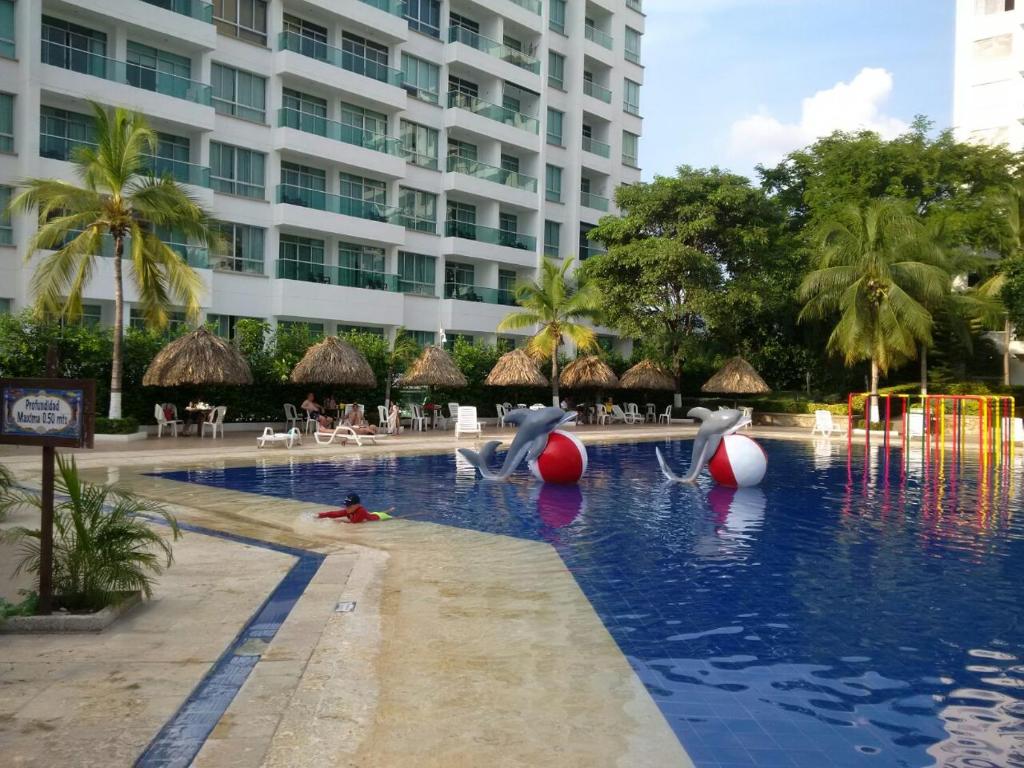 圣玛尔塔Costa Azul Suites Apartamento 603的海水中海豚的度假游泳池