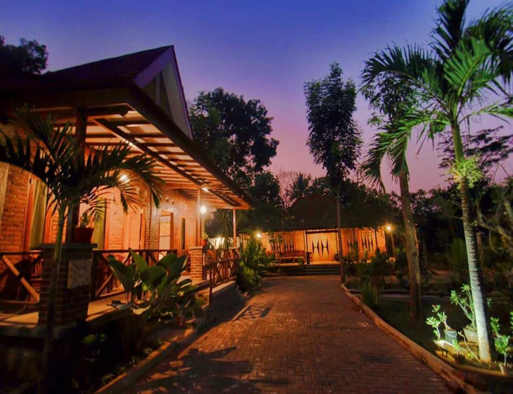 三宝垄Omah Joglo Semarang的棕榈树房屋和砖车道