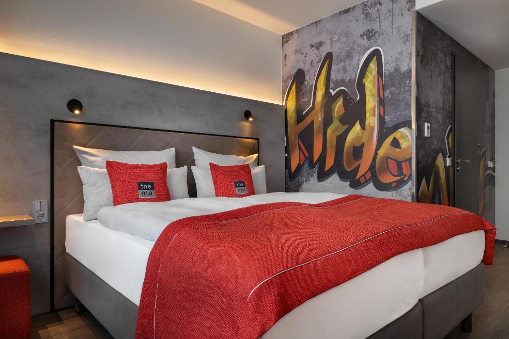 柏林the niu Hide的一间卧室配有一张带红色枕头的大床